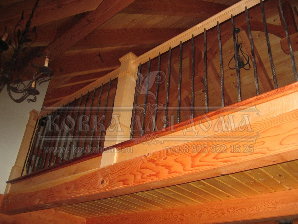 Деревянная лестница с коваными перилами с прямыми витыми балясинами и деревянным поручнем и столбами.