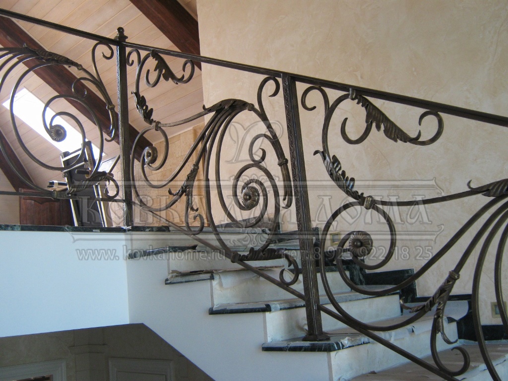 Кованые перила для лестниц в доме с декоративными балясинами и литыми патинироваными элементами под золото.