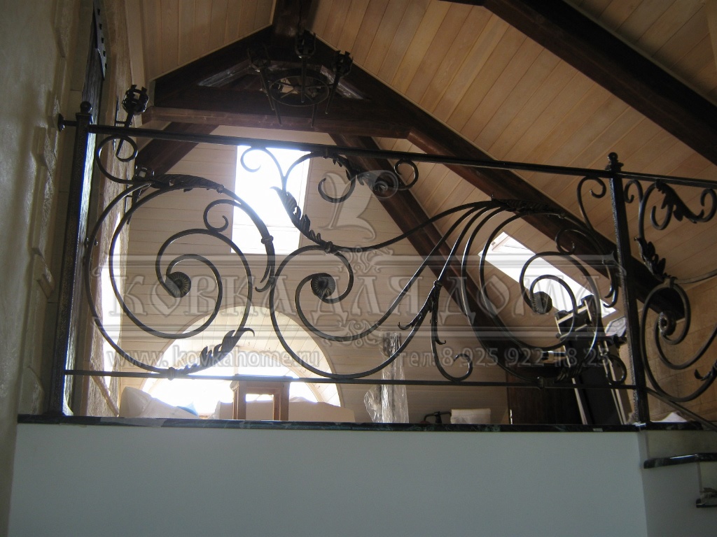 Кованые перила для лестниц в доме с декоративными балясинами и литыми патинироваными элементами под золото.