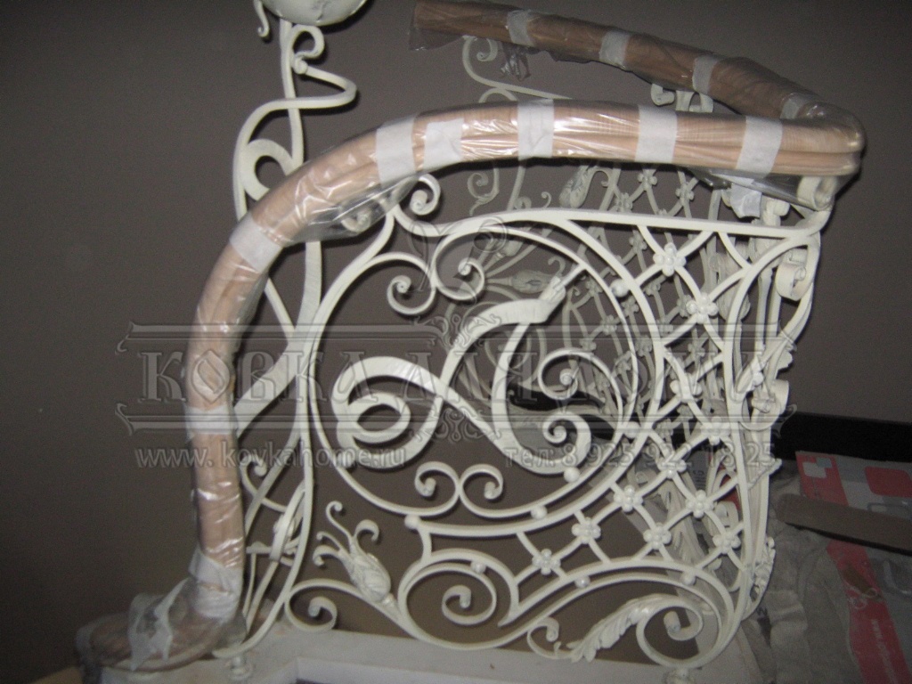 Классические белые кованые винтовые перила с декоративными художественными балясинами ручной ковки и деревянным винтовым поручнем.