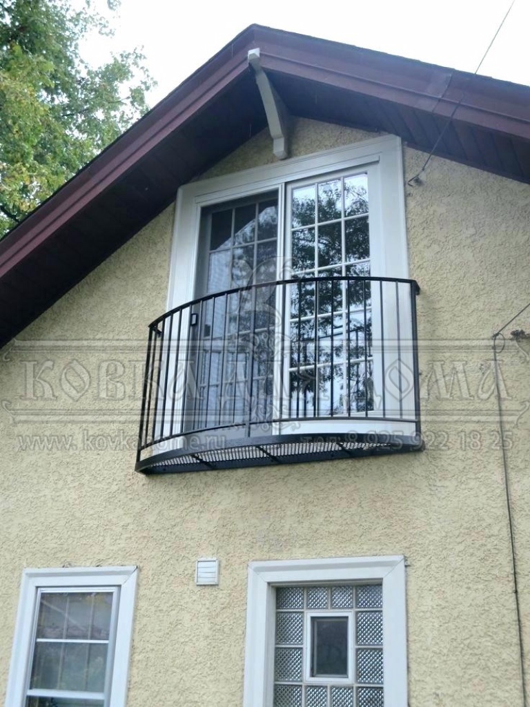 Радиусный французский балкон с перилами художественной ковки.